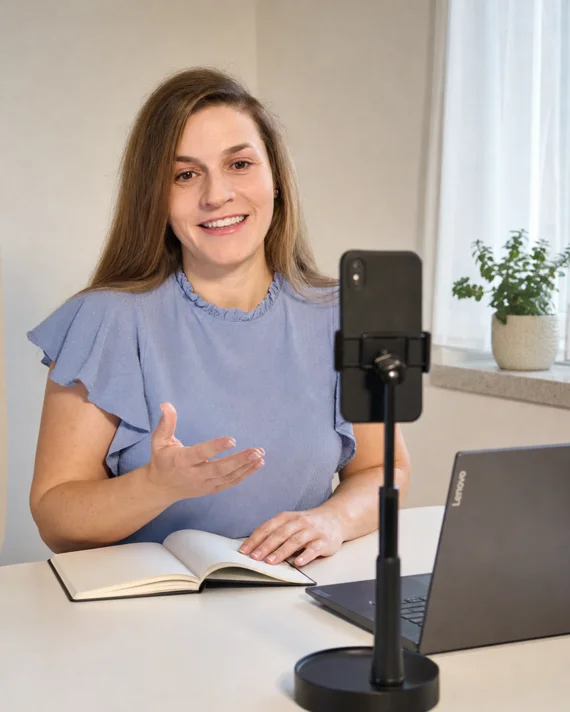 Jitka Lopez recording a piece of content on a phone at her desk